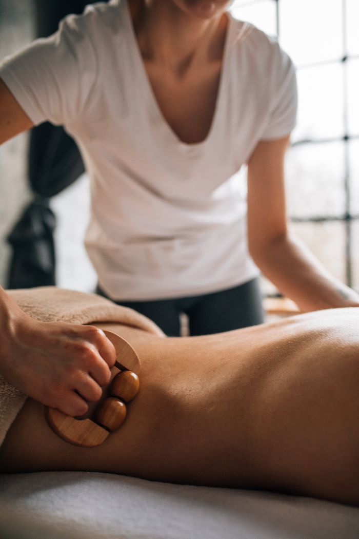 services-01 A rejuvenating massage therapy session with a wooden roller in a serene spa setting.