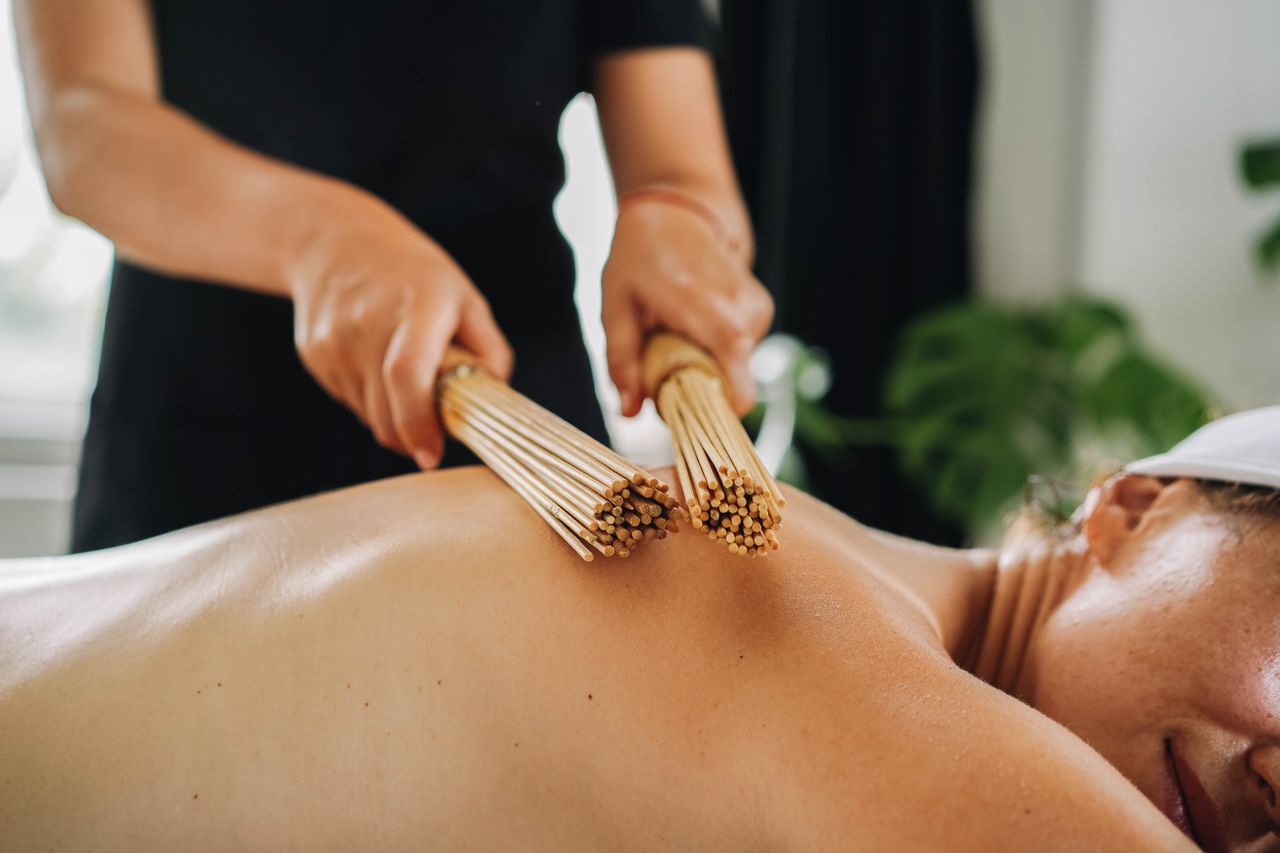 services-02 A soothing bamboo stick massage in a serene spa setting, promoting relaxation and wellness.